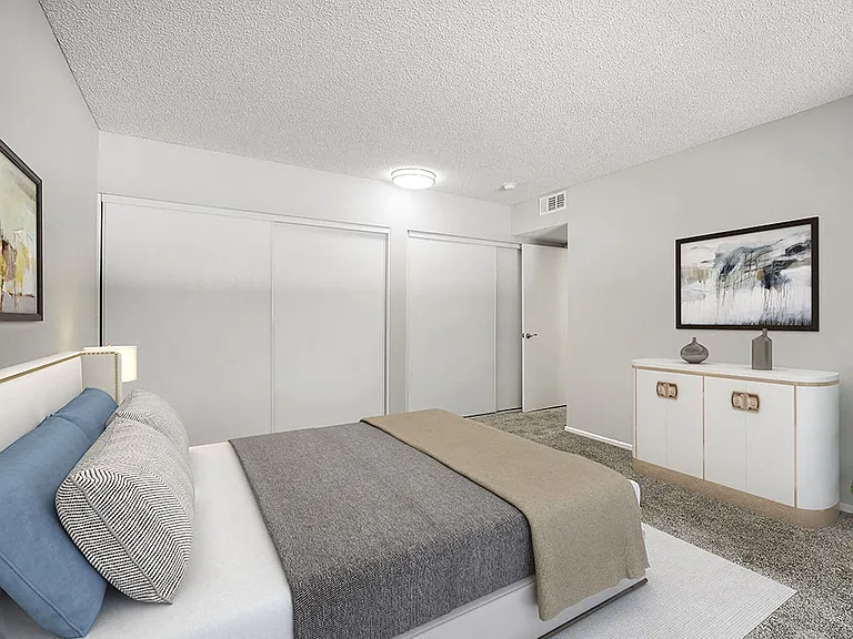 Large carpeted private bedroom showing sliding door closets.