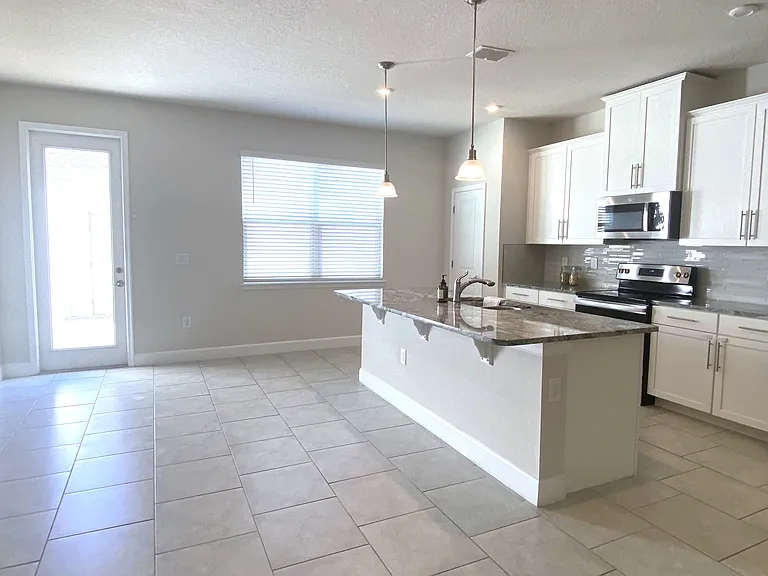 Kitchen with marble granite counter top, titled backsplash, all stainless steel appliances, all soft close drawers