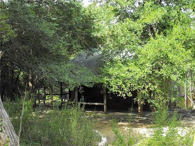 cabin nestled in the woods with covered front porch