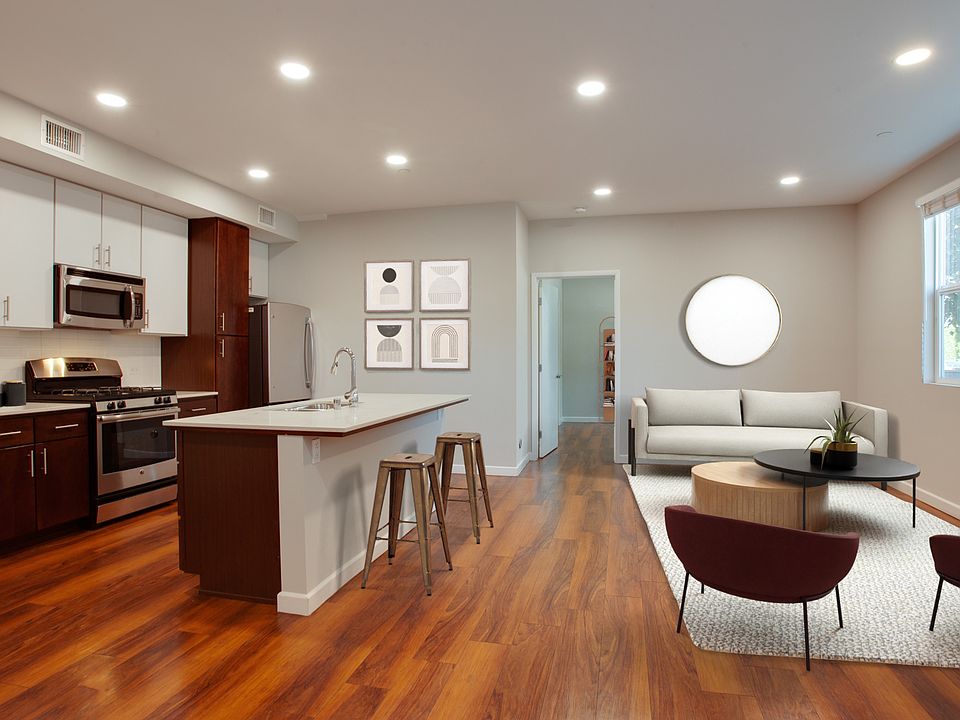 Renovated kitchen with an island, quartz countertops, and hardwood floors