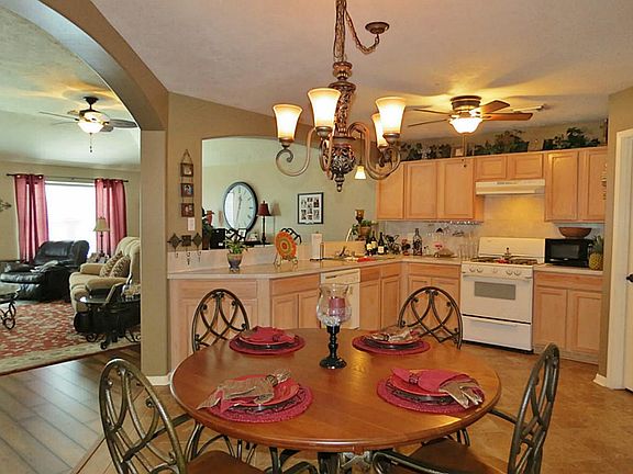 This home has an open floor plan, archways, and hard surface flooring in the living room, hallway an