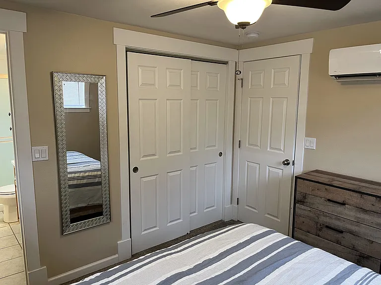 Bedroom with dual sliding closet doors . Doorway to right leads into living area and door way to left leads into bathroom