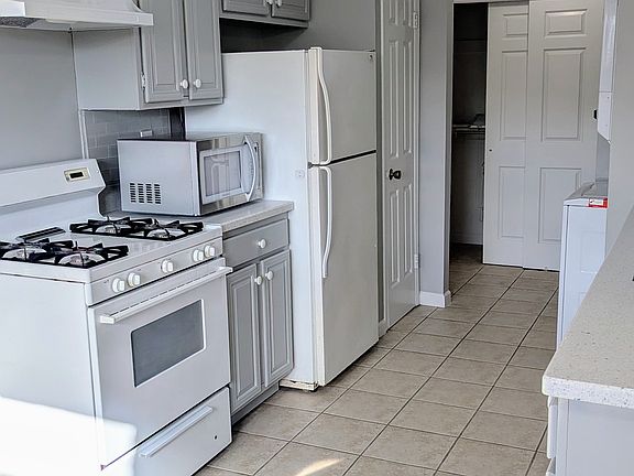 Kitchen with sandstone countertops and plenty of cabinets.