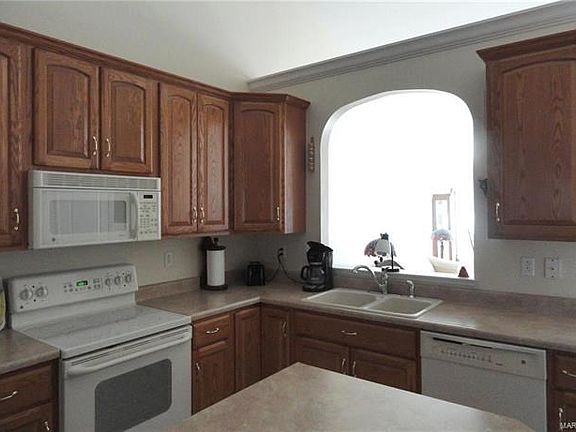 Custom oak cabinetry and island with all appliances staying.
