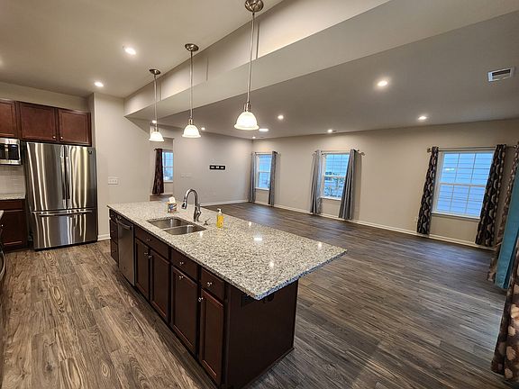 Heart of the Home - Chef-inspired kitchen featuring gleaming granite countertops and a seamless view into the light-filled living and dining areas_perfect for modern, open-concept living.
