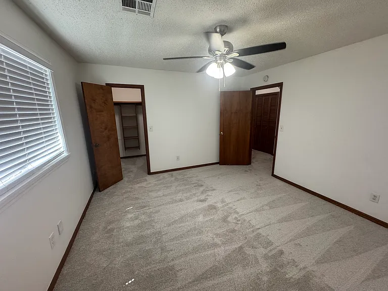 Secondary bedroom with ceiling fan and Large walk-in closet
