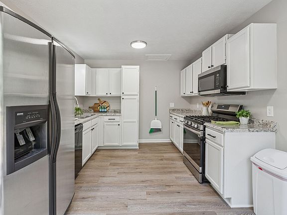 Kitchen with gas stove, microwave, dishwasher, fridge.