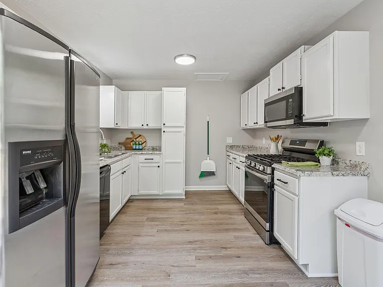 Kitchen with gas stove, microwave, dishwasher, fridge.