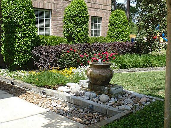 Sidewalk leading to entry lined with pavers & foliage