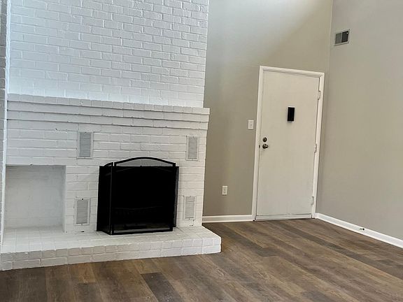 Bright living room with wood burning fireplace, vaulted ceilings and new LVP flooring