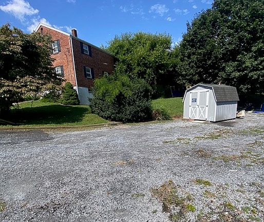 Large parking lot and small shed for storage of bikes and mower.
