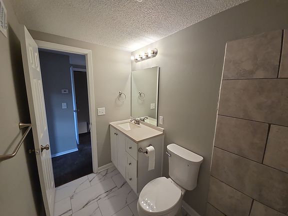 Full bath featuring tiled shower surround, updated vanity, and modern fixtures