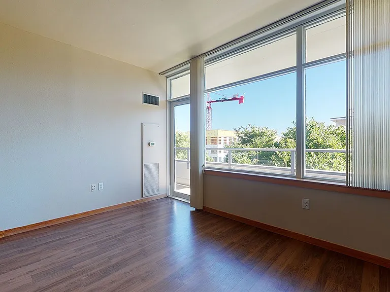 Apartment Living Room with Wood-Style Flooring and Balcony.