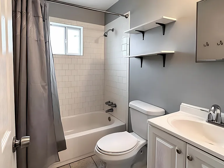 Shared bathroom with full tub and shower curtains.