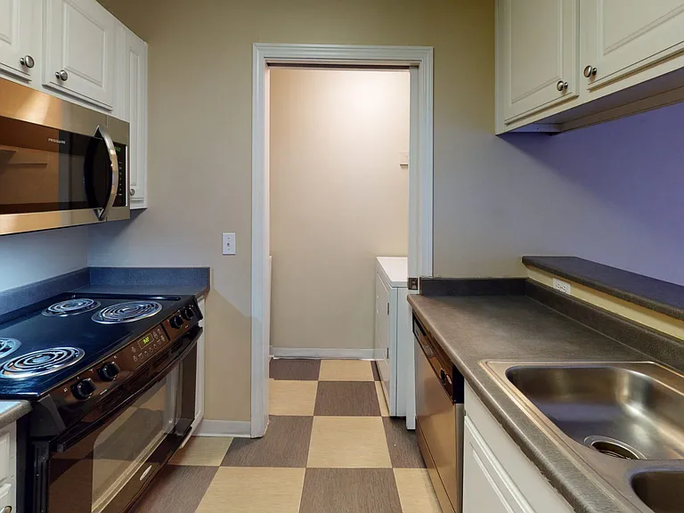 Apartment kitchen with tile flooring.