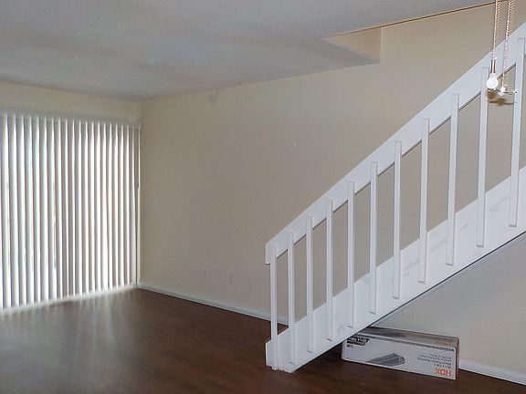 Living room in laminate floor with stairway to the second floor and sliding door to the patio.