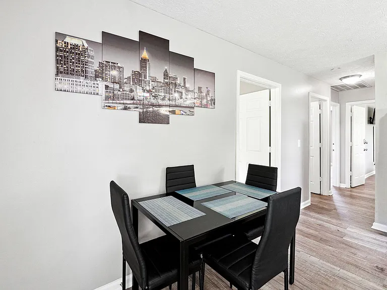 Dedicated dining area with a four-seat table, durable flooring, and open access to nearby rooms for easy everyday meals.