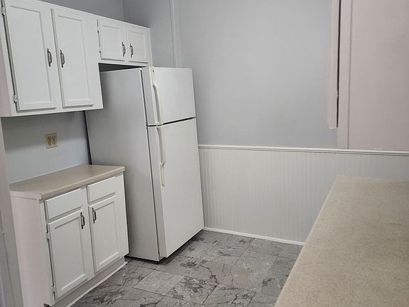 One side of the kitchen with fridge and counter space