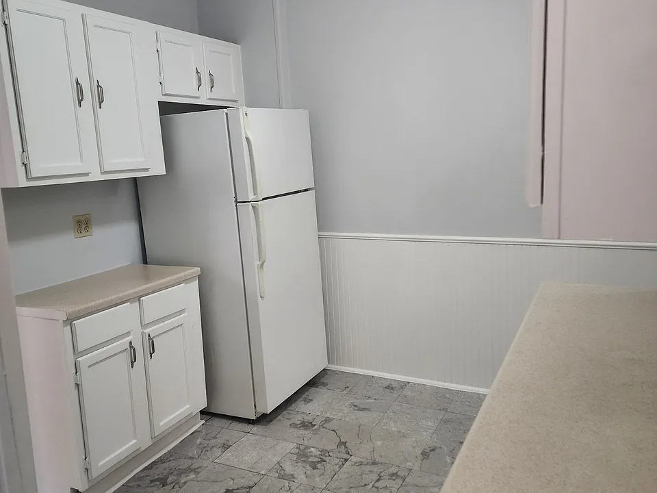 One side of the kitchen with fridge and counter space