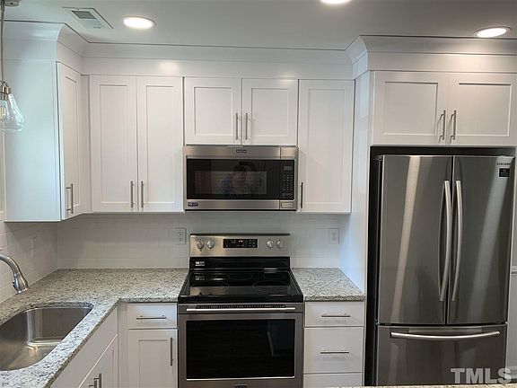 Kitchen with white cabinets, stainless appliances & granite