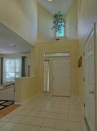 The tiled foyer  with a dramatic vaulted ceiling  opens on to the formal living and dining area.