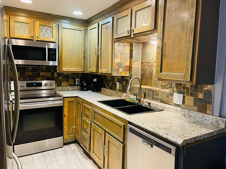 Kitchen with full size stainless steel appliances. Fridge, glass cooktop, oven, microwave, dishwasher. And small appliances toaster and coffee maker.