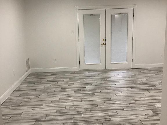Large living dining area with built in LED lights on dimmer switch, built in ceiling fan, French Doors with verticals in between the double-pain glass. Designer tile throughout that looks like weathered wood cedar planks.