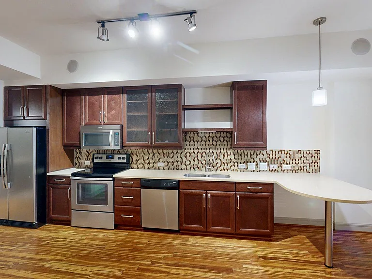 Apartment Kitchen with Stainless Steel Appliances, Dining and Living Room with Wood Style Flooring