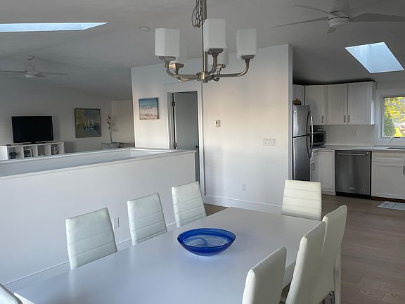 View to kitchen from dining area. You can see half bathroom and living room