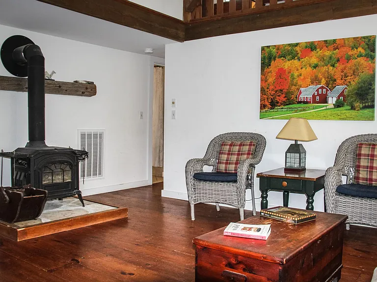 New wood stove sits on marble hearth in living room.