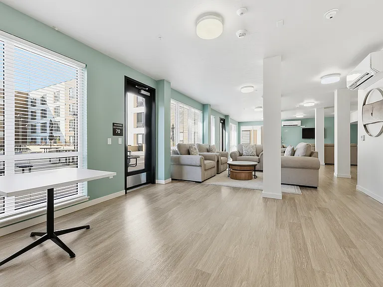 A spacious community room featuring a full kitchen, comfortable couches, and tables_perfect for everyday gatherings or reserving for private parties and special events.