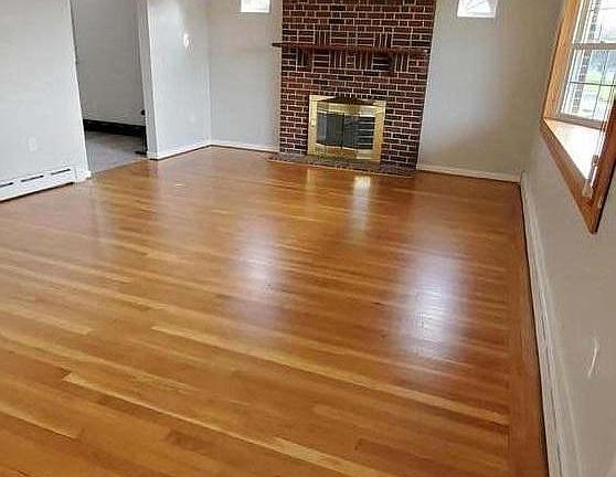 Large living room with fireplace, coat closet and bay window.