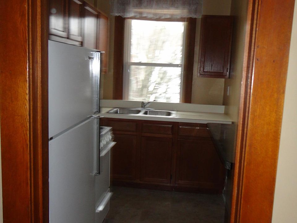 Small kitchen furnished with a refrigerator and apartment-sized gas stove.