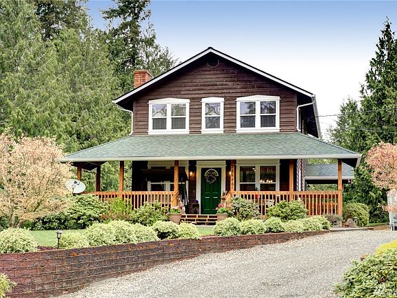 Beautiful landscaping welcomes you up to the long, covered front porch. 