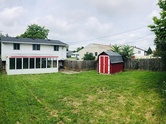 Back of the house with covered back patio, storage shed and a completely fenced in back yard.