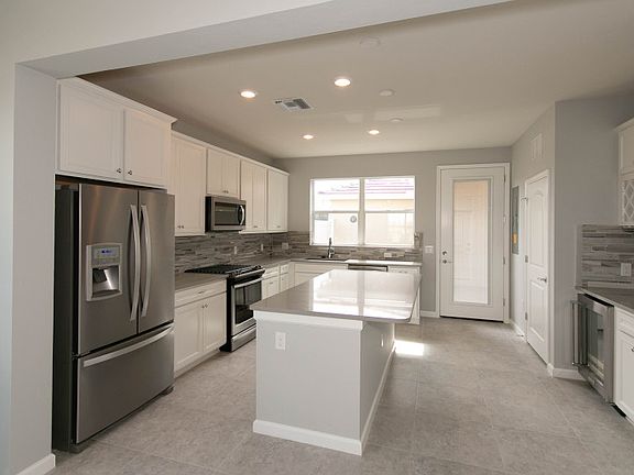 Kitchen with stainless gas appliances and decorative tile backsplash