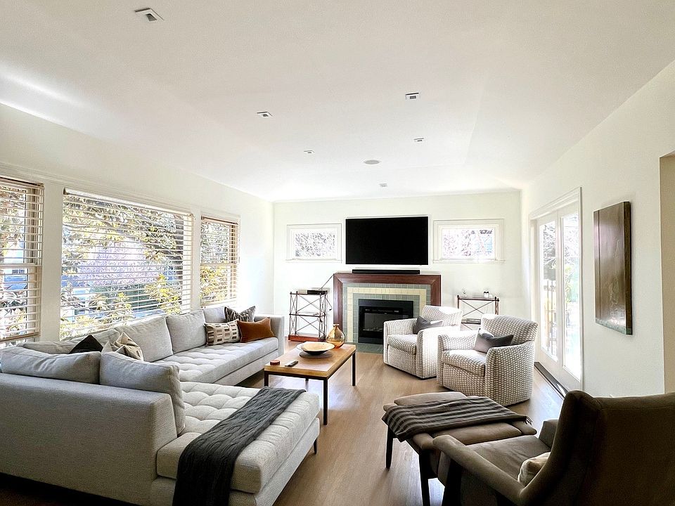 Living room features large screen television, Sonos sound system and electric fireplace