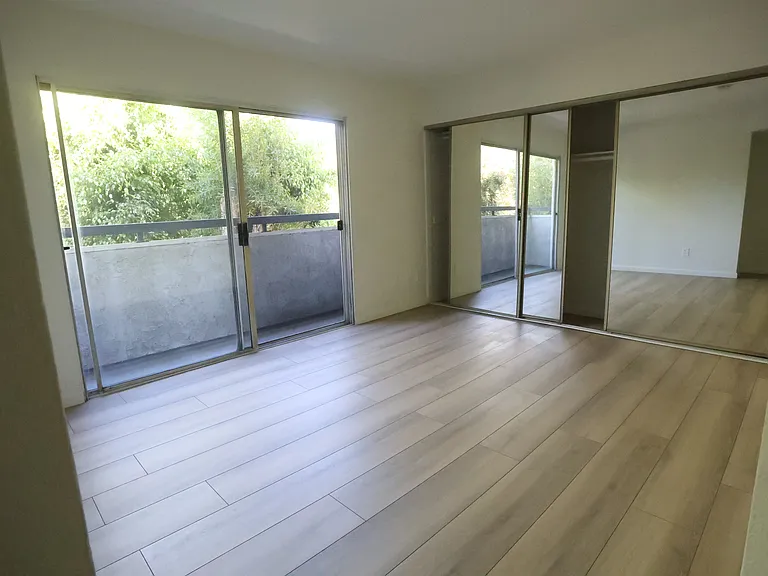 Primary Upstairs Bedroom w/ reach-out balcony and wall-to-wall mirrored closet