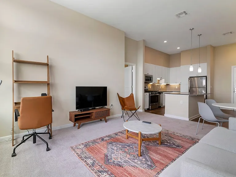Furnished+ apartment homes come outfitted with a sofa, side chair, side table, coffee table, office chair, desk, TV stand and 50" Television (Representative Image exact items and style of furnishings may vary)