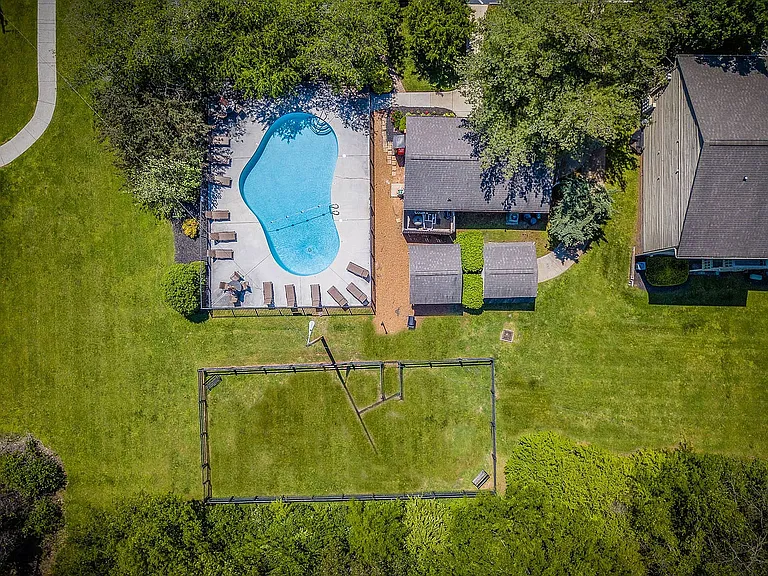 Experience tranquility in this expansive outdoor oasis, featuring a refreshing pool and vast green spaces.