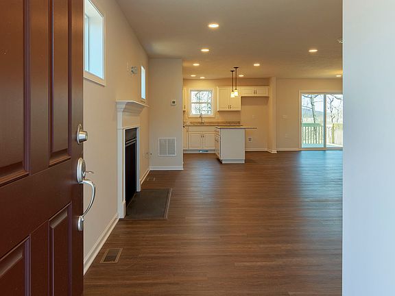 Foyer entry - facing great room area with luxury vinyl plank flooring and gas fireplace