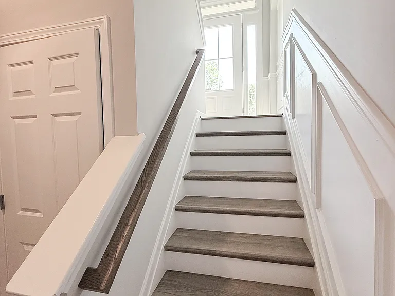 Stairs to basement storage, closets, and garage entry.