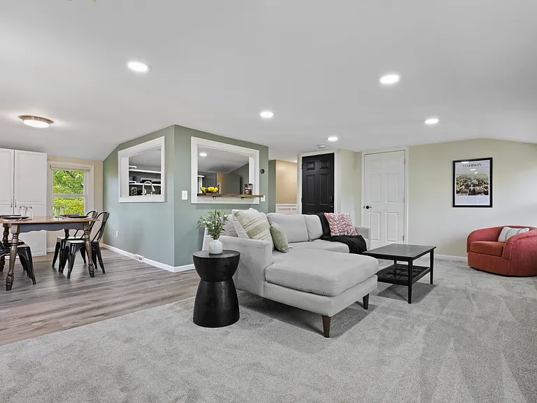 Open concept living with the living room, dining and kitchen area. The living room has a comfy couch, 58" smart TV, and corner swivel chair that's perfect for morning coffee and sight seeing the neighborhood.