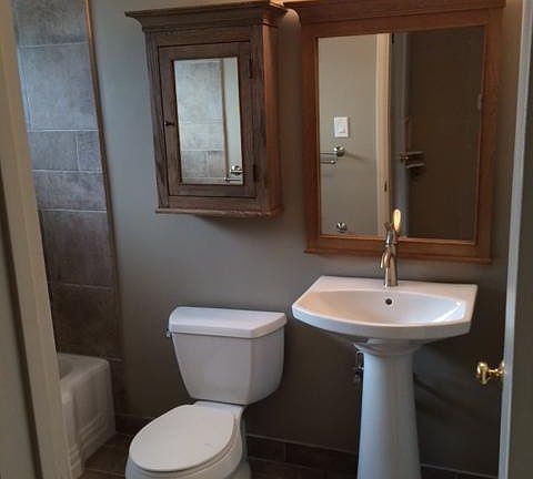 Fully renovated bathroom including new tile surrounding tub and on the floor, all new fixtures, medicine cabinet, mirror and lighting.