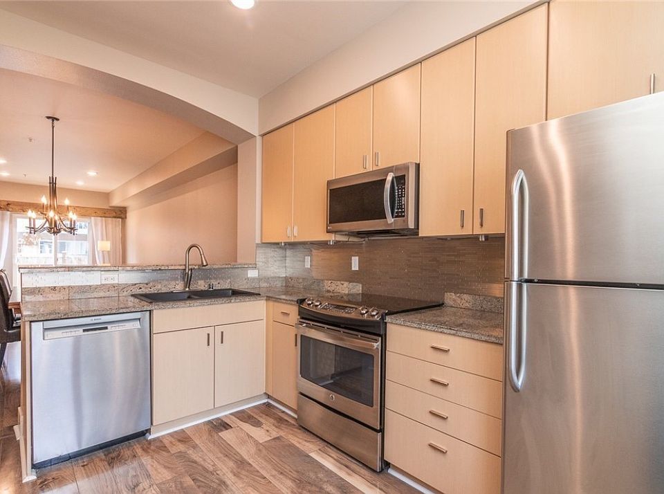 Modern kitchen equipped with sleek stainless steel appliances and abundant cabinetry.