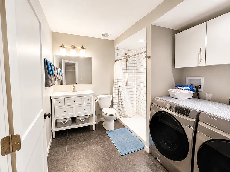 Spacious Laundry Room with New Samsung Washer and Dryer - Third Bathroom with Large Tile Shower