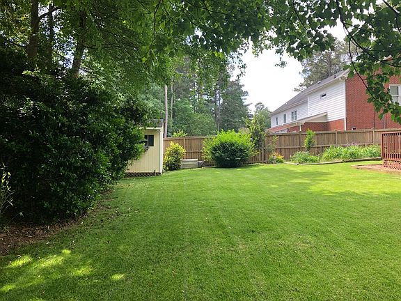 Fully fenced backyard with storage building.