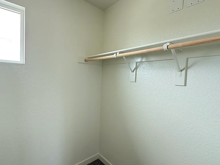Primary bedroom features a spacious walk-in closet with plenty of room for organized storage.