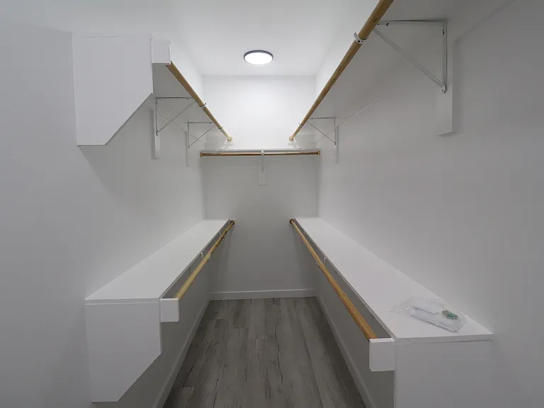 Spacious walk-in closet in the primary bedroom with built-in shelving and hanging space for easy organization.