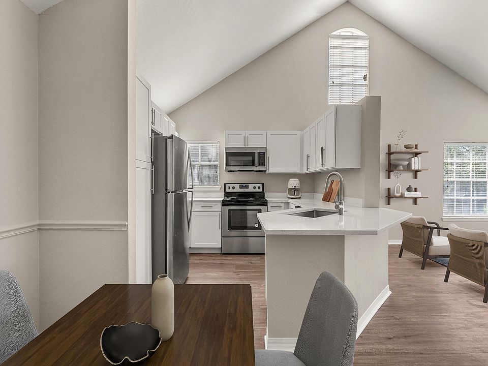 Experience the elegance of a contemporary living space with an open kitchen and stylish furnishings.